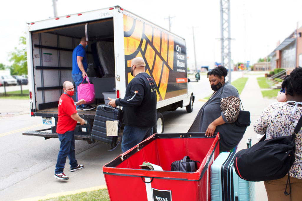 Five people loading up a city rescue mission moving truck