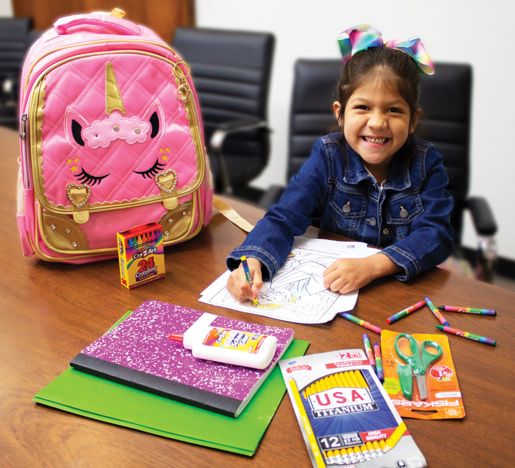 A young girl is coloring using school supplies given to her by city rescue mission