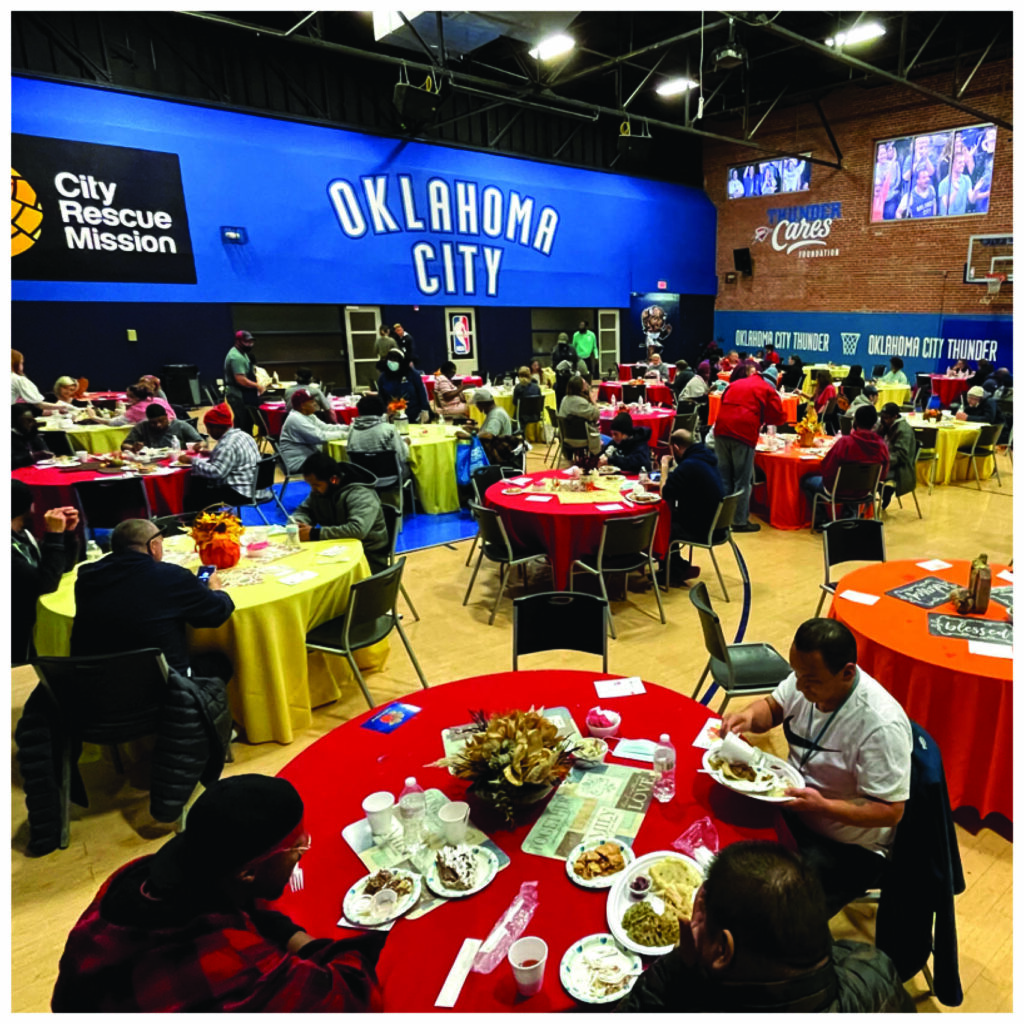 multiple homeless people eating in a Oklahoma city thunder gymnasium