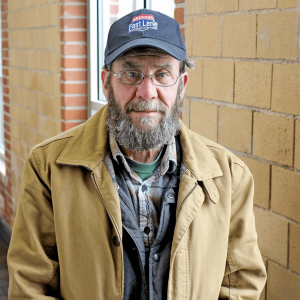 A man elderly man in a tan jacket